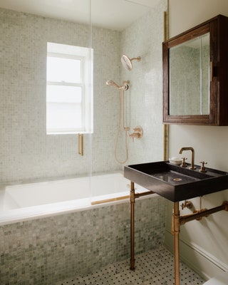 In the guest bathroom Lee used the same tile options as in the primary bathroom Carrara and Nero Marquina marble for the...