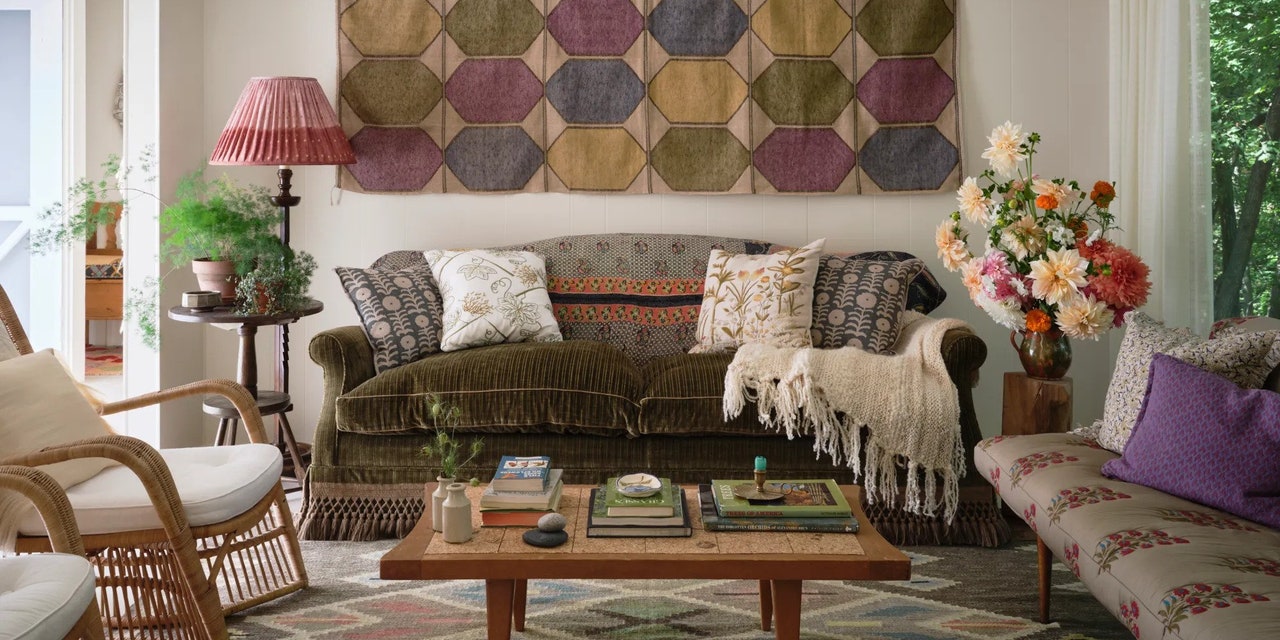 living room with midcentury modern coffee table rattan chairs a jeweltoned woven textile on the wall and an antique...